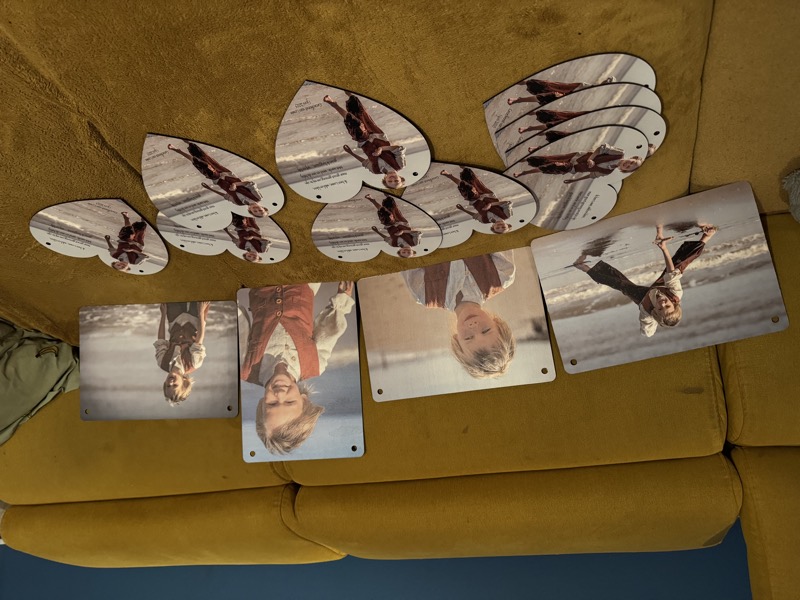 Heart-shaped keepsakes and photo panels laid out on a sofa